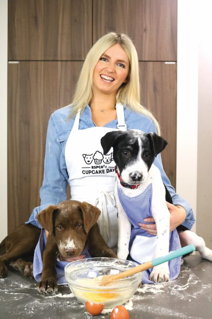 woman baking with two dogs on the table