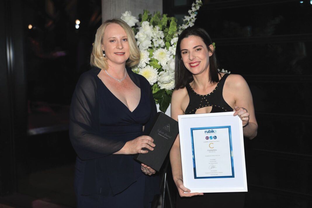 two women holding awards