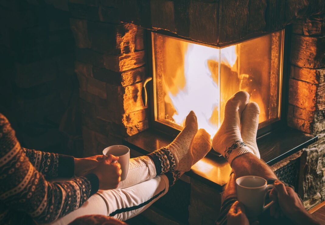 two people with their feet near the fireplace