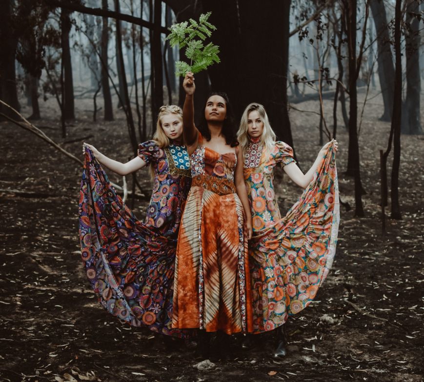 Three women model dresses from Saloon Design House in the burnt forest surrounding Braidwood.