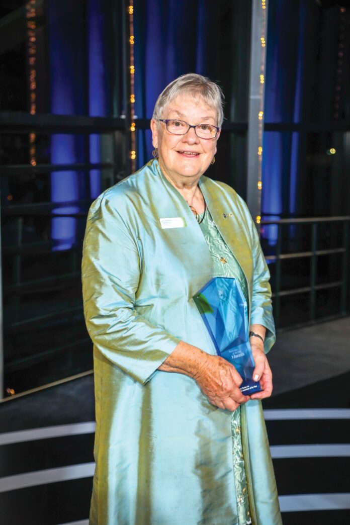 elderly woman holding an award