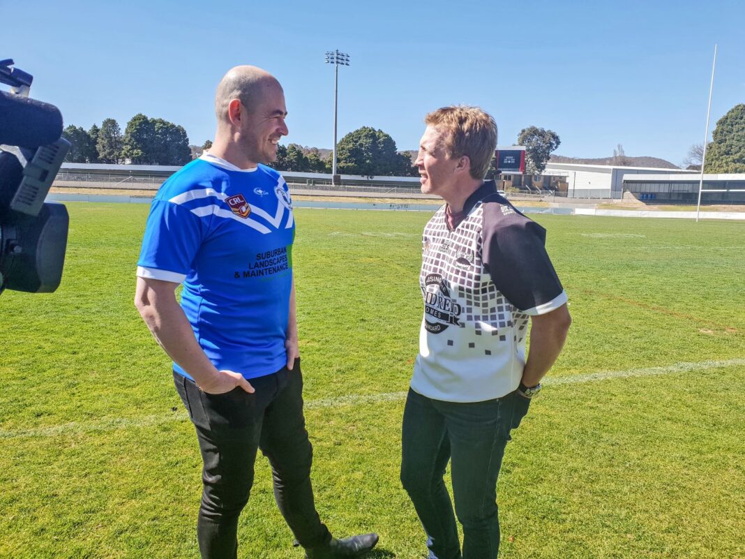 Former Raiders stars Terry Campese and Alan Tongue on a field
