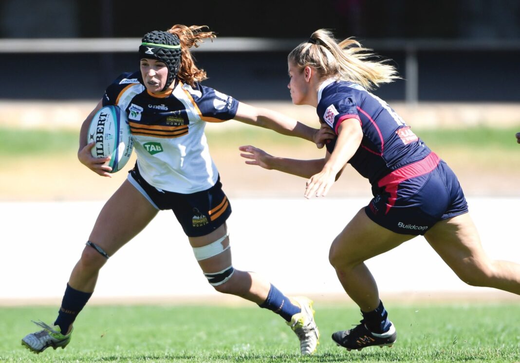 woman playing rugby being tackled