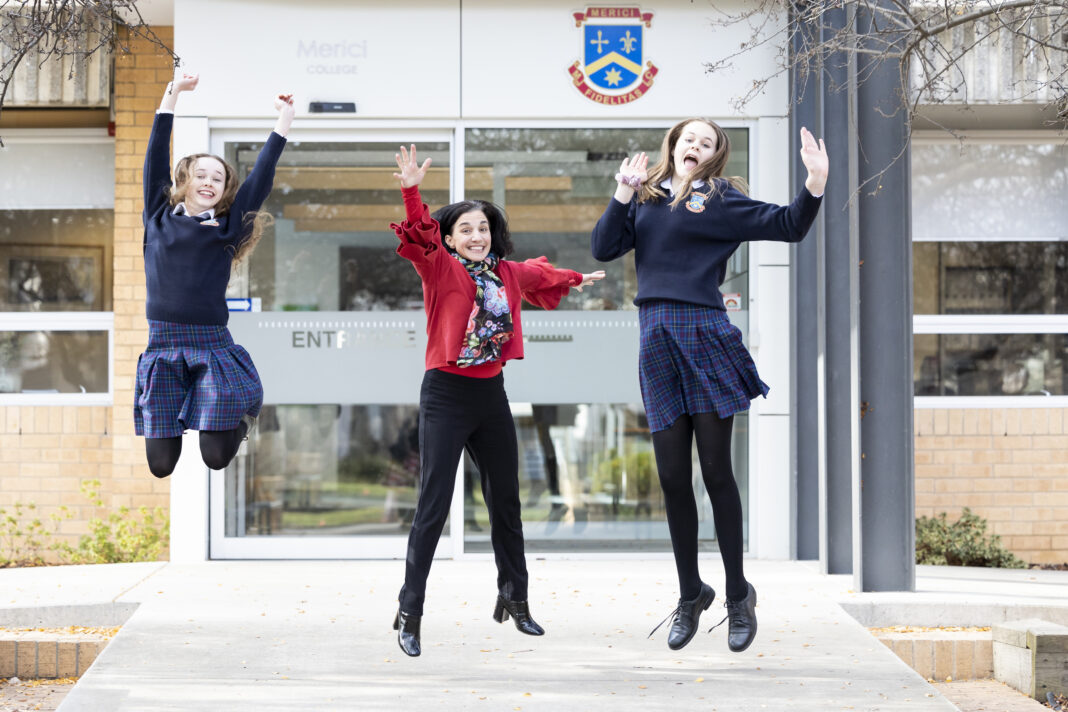 principal with two students jumping in the air
