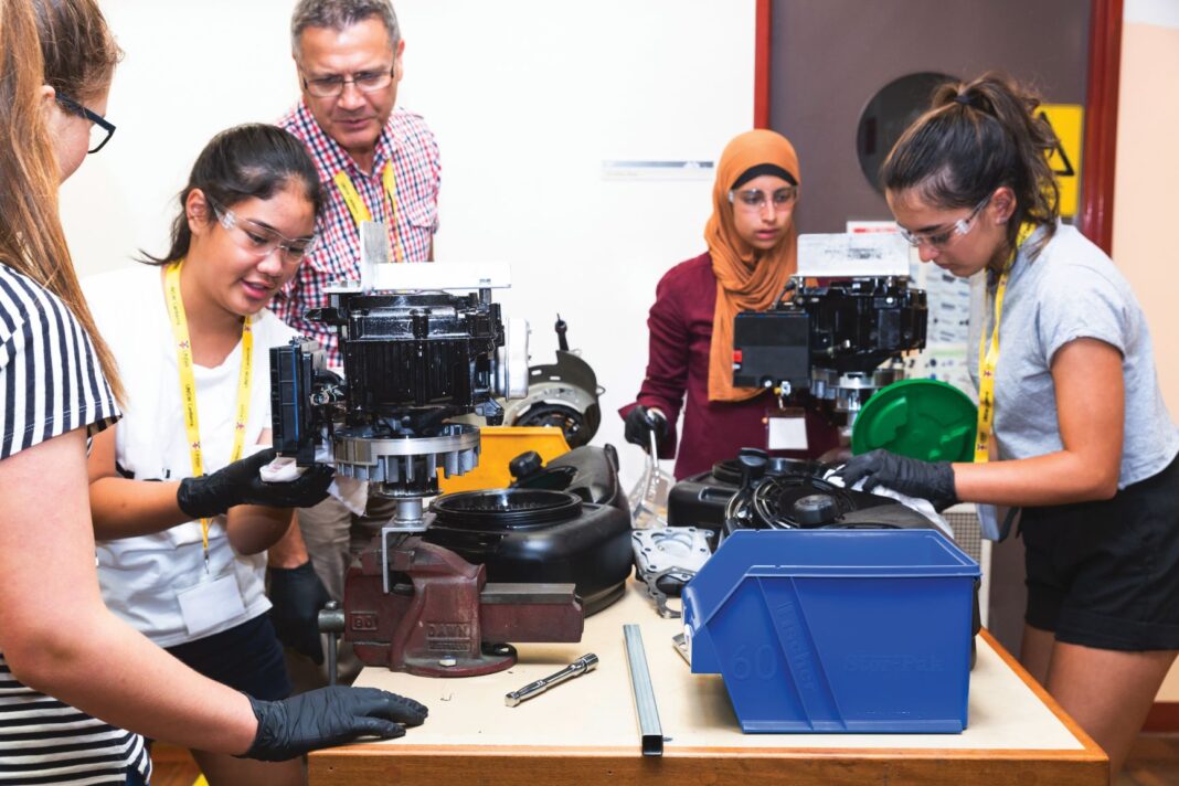 Group of people looking into microscopes