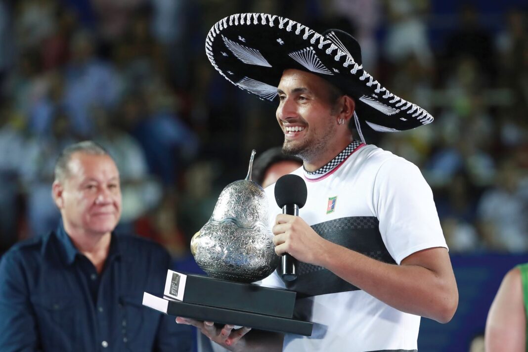 Nick Kyrgios with a sombrero on holding a trophy