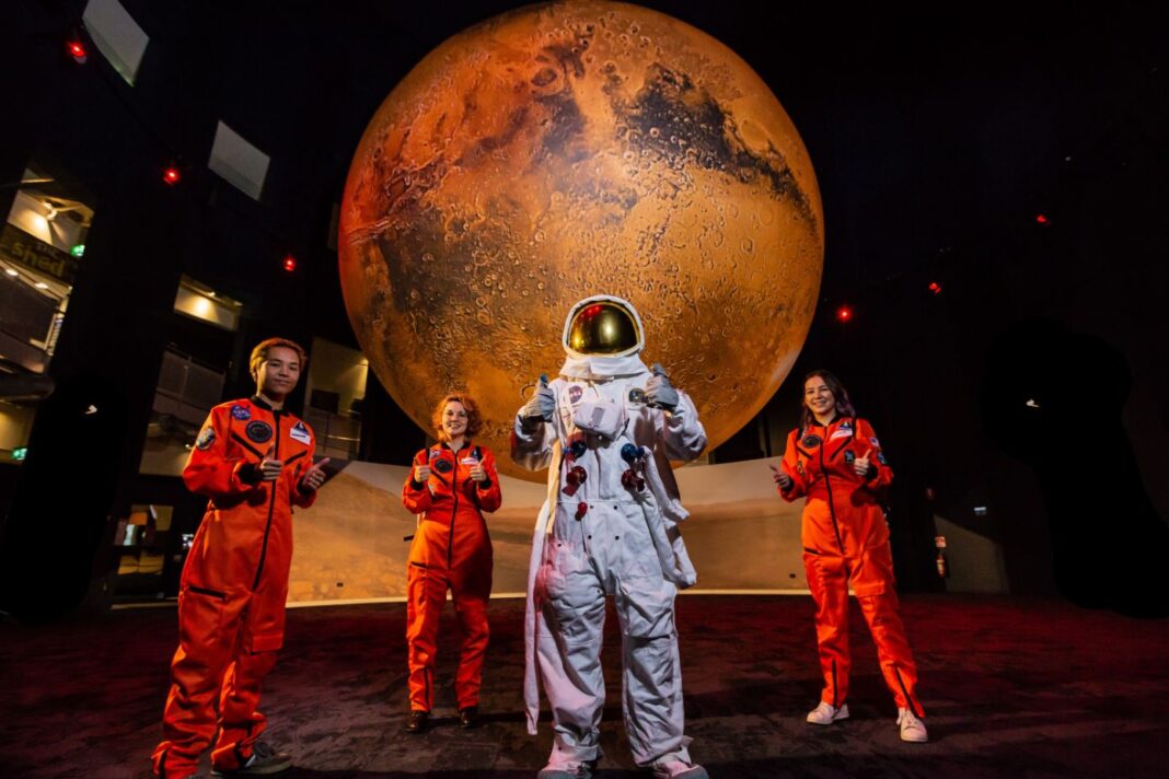 people dressed up as astronauts in front of planet