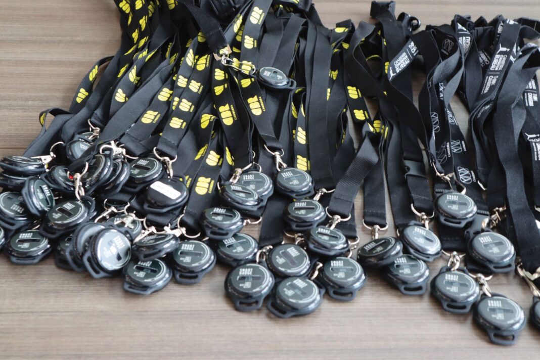 Pile of black, high-tech lanyards that vibrate when someone else comes within 1.5 metres of the wearer