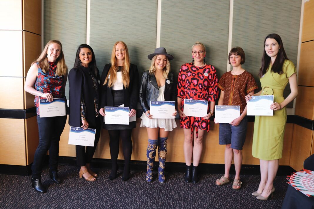 seven women holding awards