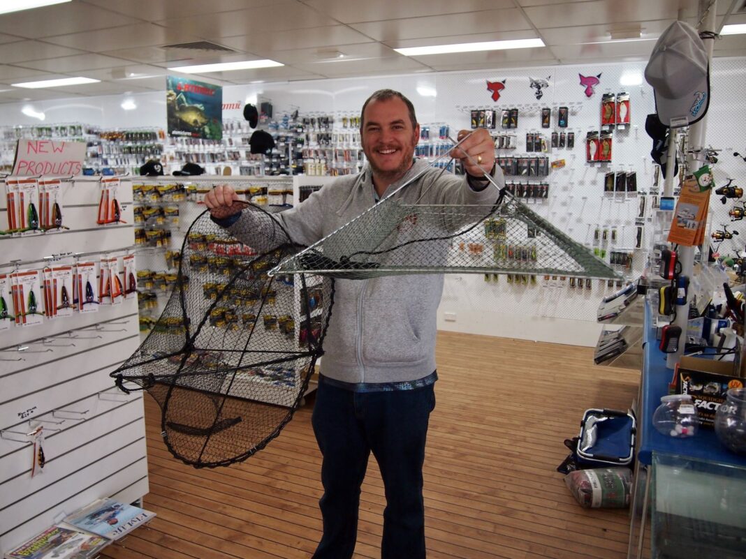 Man in fishing shop with two different types of yabby nets