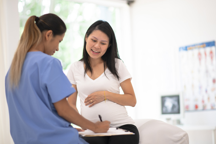 Hispanic Pregnant Woman Speaks With Her Doctor at a Check-Up