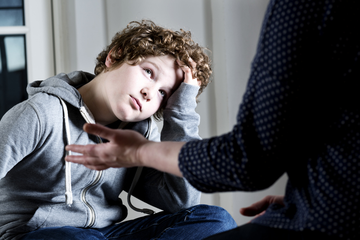 Eleven year old boy talking to a parent,guardian or social worker