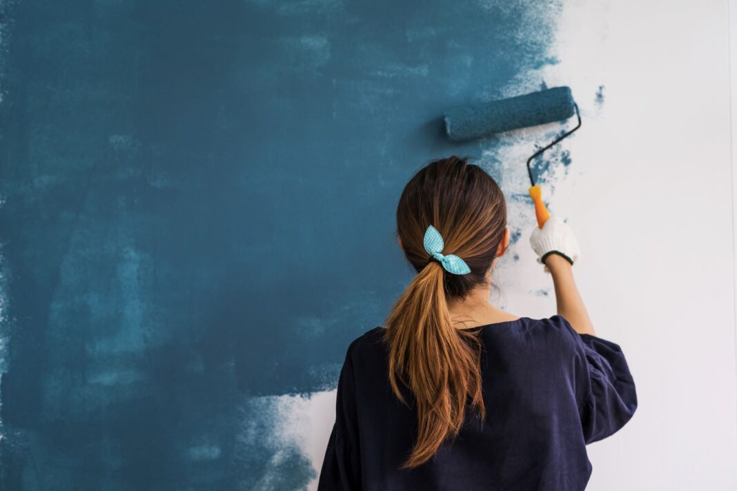 woman painting a white wall