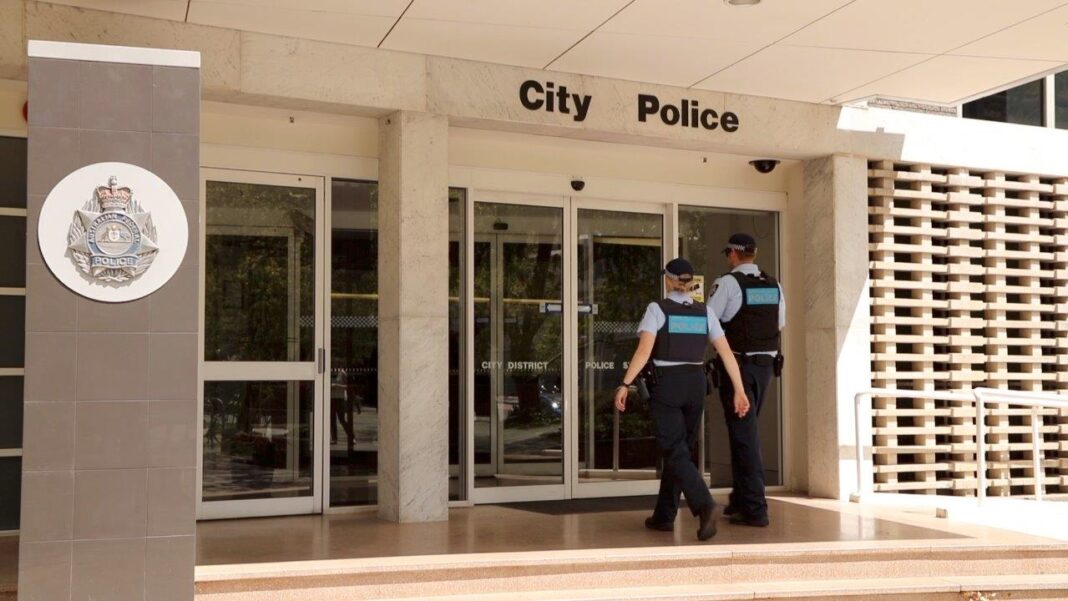Two police officers walking into City Police station