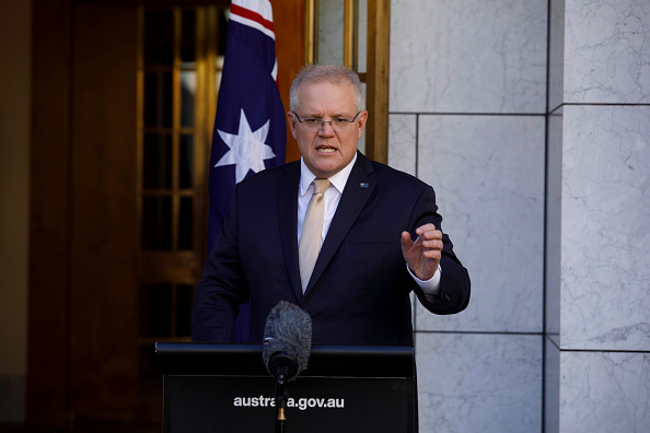 Middle aged man in suit and glasses, Australian Prime Minister Scott Morrison standing at a lectern outside parliament house