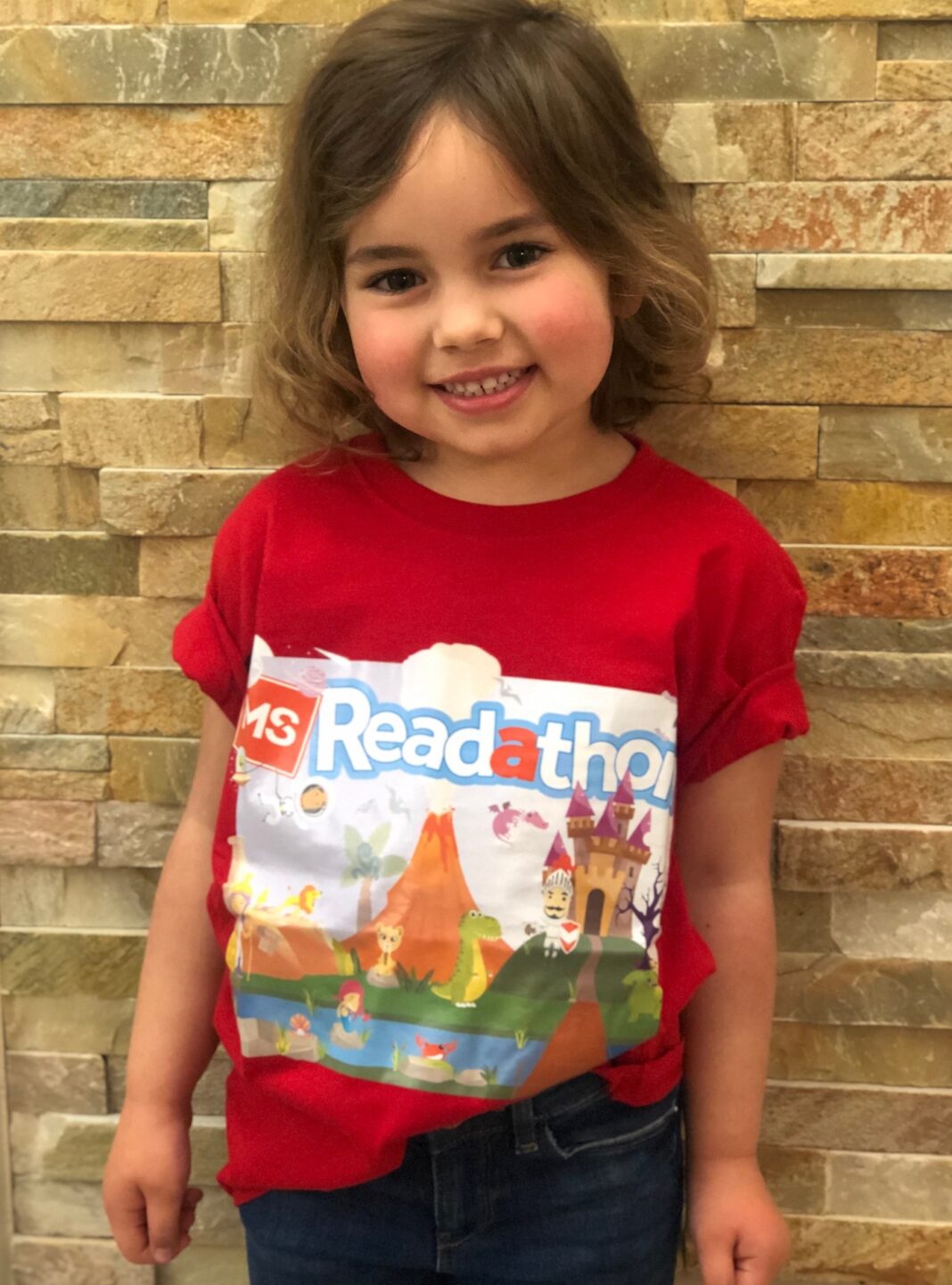 Smiling 4-year-old girl wearing red MS Readathon t-shirt