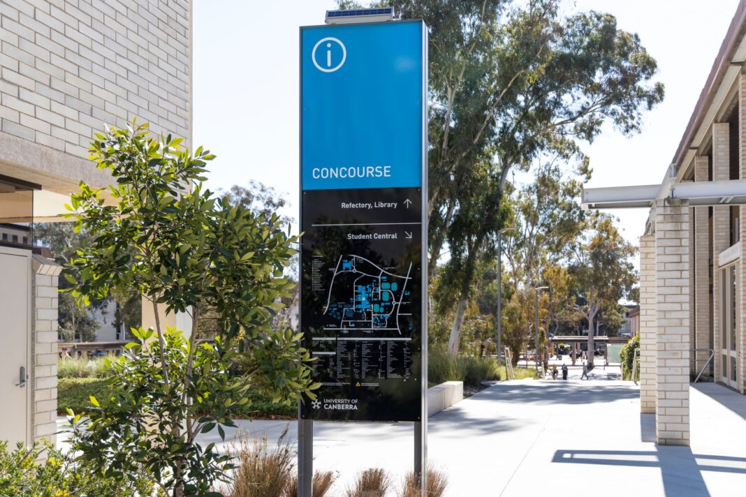 A blue sign and map at a university campus