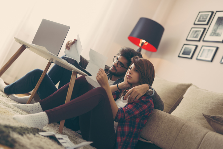 Young couple doing their paperwork together, paying taxes online