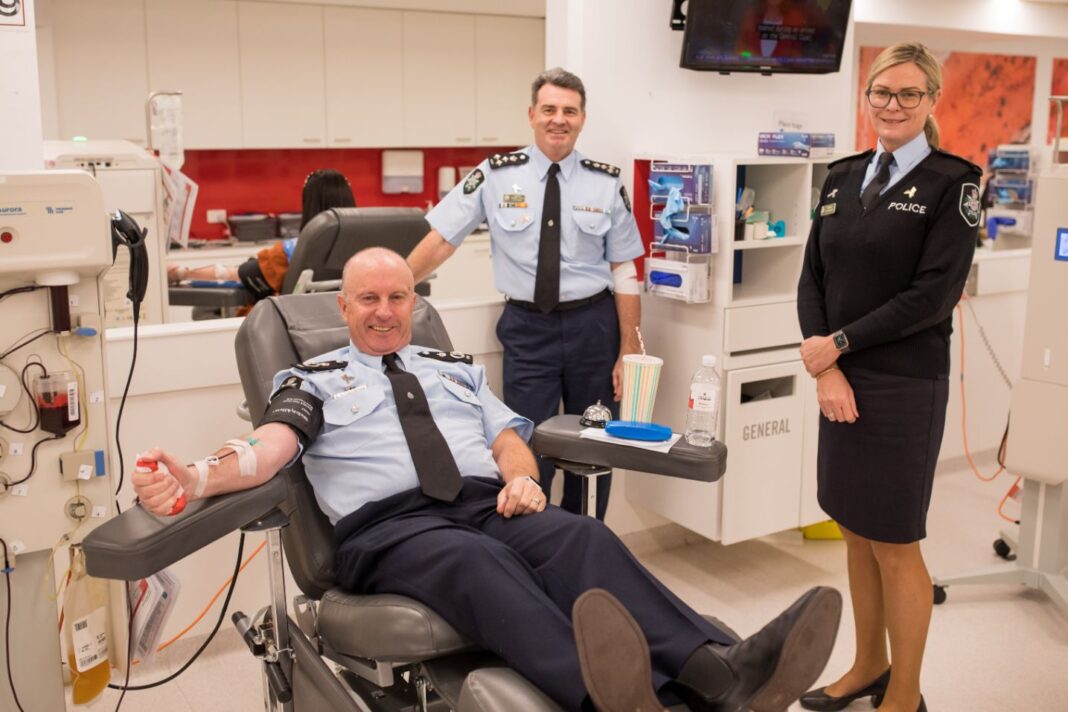 ACT Chief Police Officer Neil Gaughan (in the chair) donating blood with colleagues and Deputy Chief Police Officers Michael Chew and Liz McDonald.