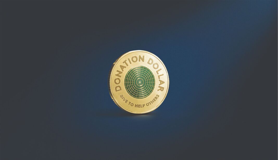 The Donation Dollar $1 coin unveiled by the mint, which features a green and gold design with a reminder for the receive to donate it.