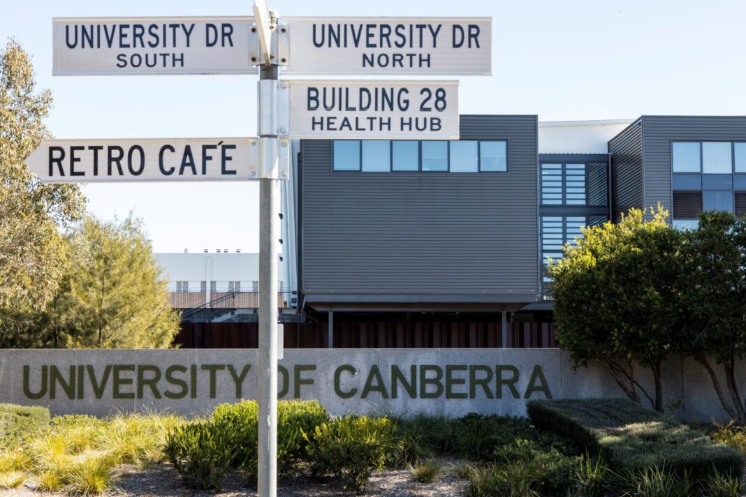 University of Canberra sign and buildings with University Drive street sign in the front pointing to local landmarks