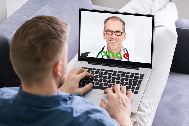 Close-up Of A Man Videoconferencing With Happy Doctor On Laptop