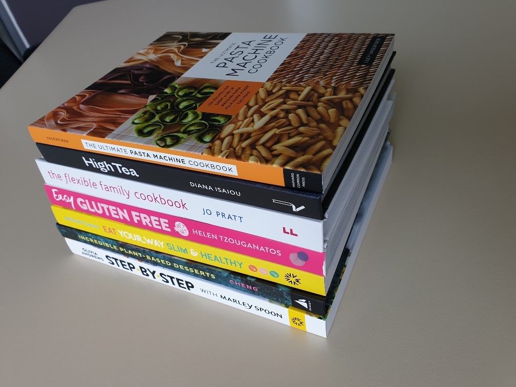Stack of 7 cookbooks on a table