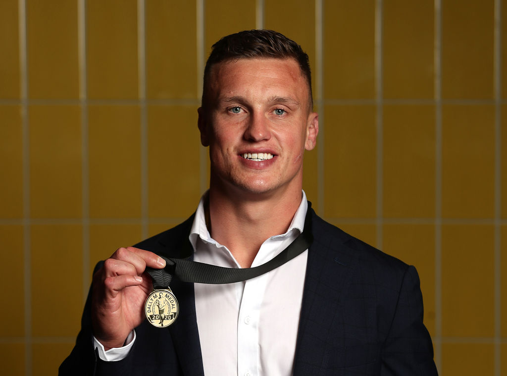 Handsome young smiling rugby league footballer holding a medal