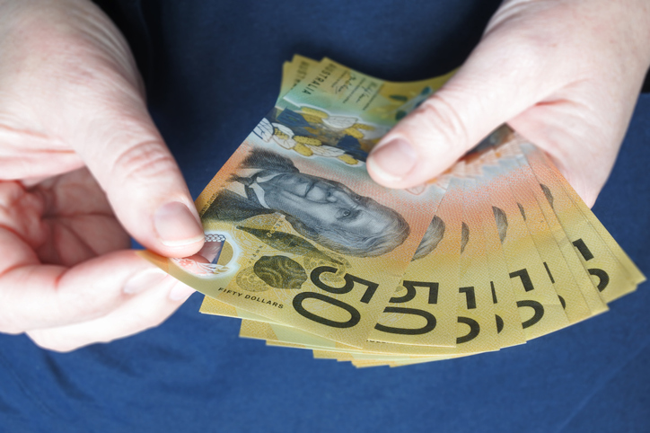 Australian woman counting Australian dollar banknotes