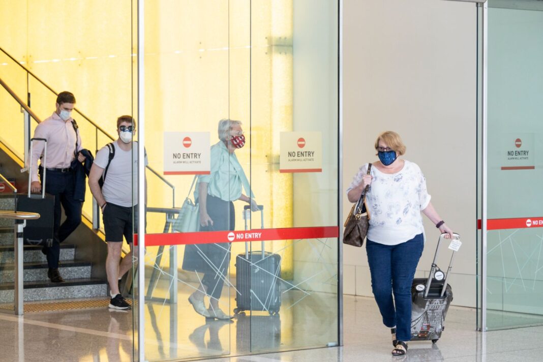 passengers from Adelaide flight wearing masks at Canberra Airport terminal