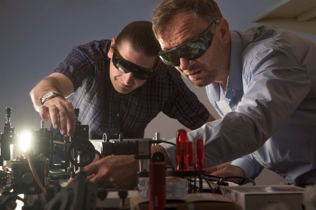 two male scientists using equipment in a laboratory