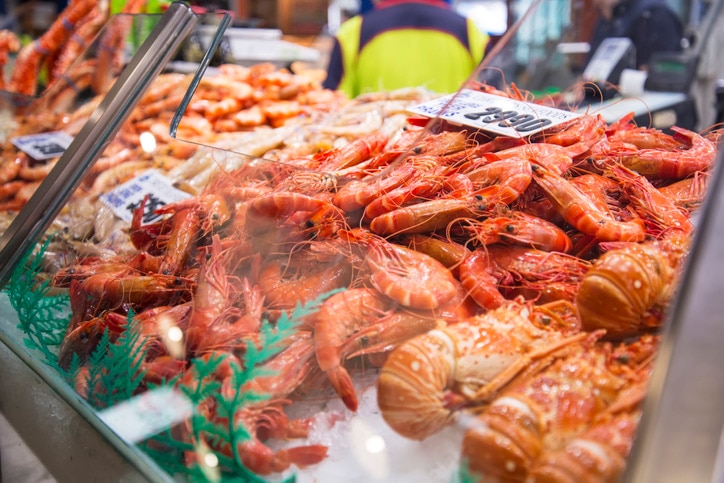 cooked prawns and lobsters on ice in a fish market