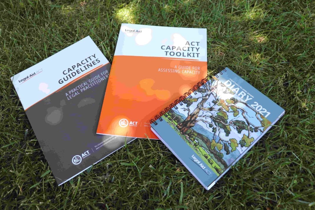 Three government publications laid out on green lawn