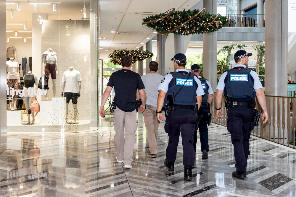 Three police officers and two security guards in a shopping centre