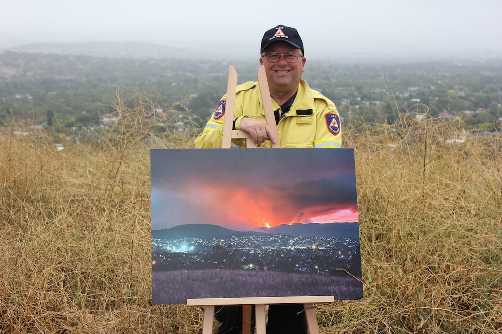 Gary Hooker with his photograph of the Orroral Valley fire