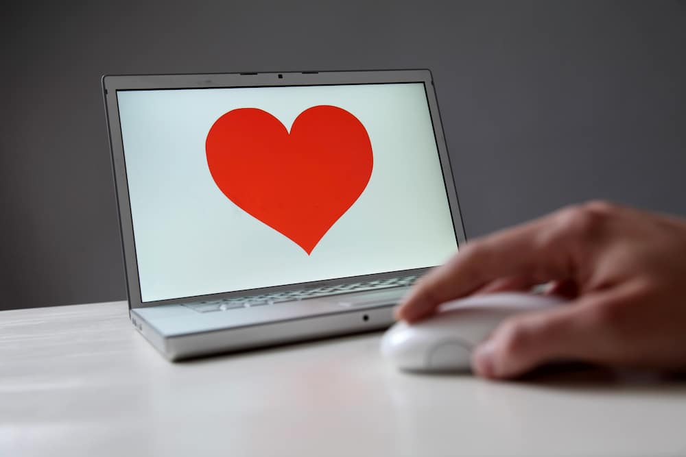 A photo of a laptop with a large red love heart on the screen, to symobilse online dating in Australia.