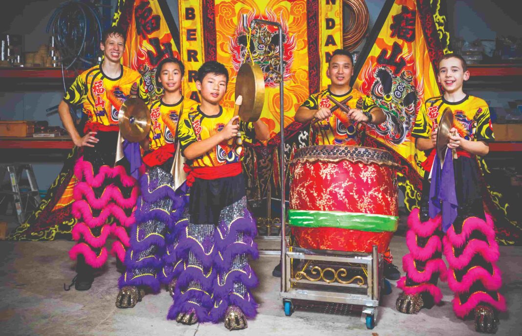 Five males in colourful Chinese lion dancing outfits