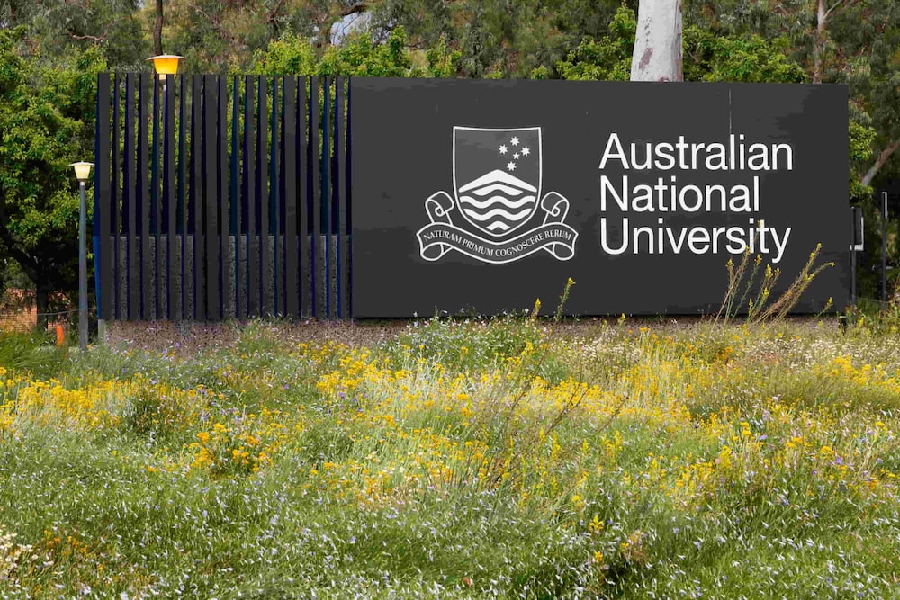 Australian National University signage among green grass