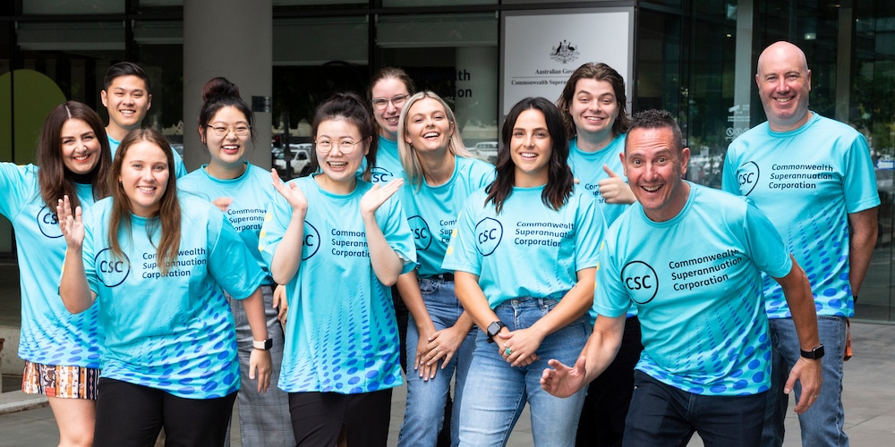 Team members from the Commonwealth Superannuation Corporation smile in their team shirts.