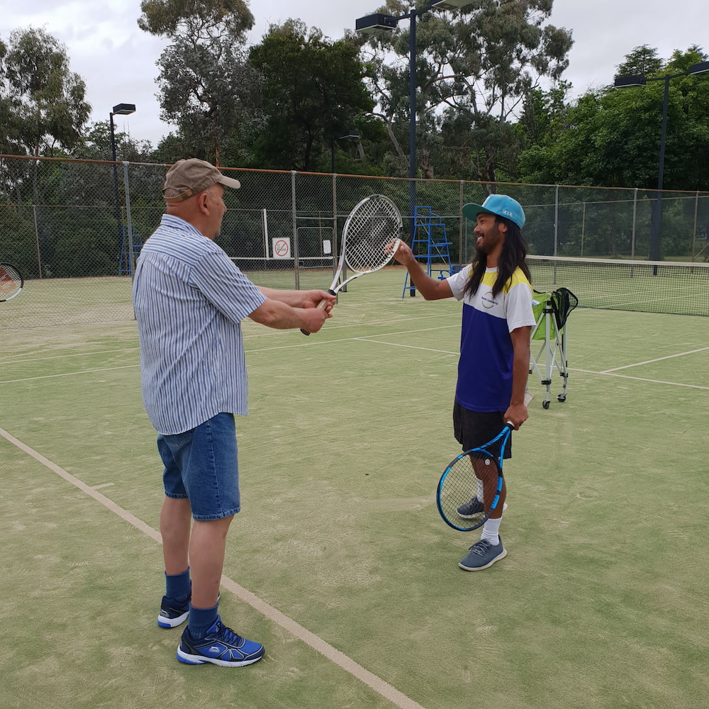 Havelock House resident Parvis learning the tennis ropes from Tennis Canberra coach, Robbie Manzano.