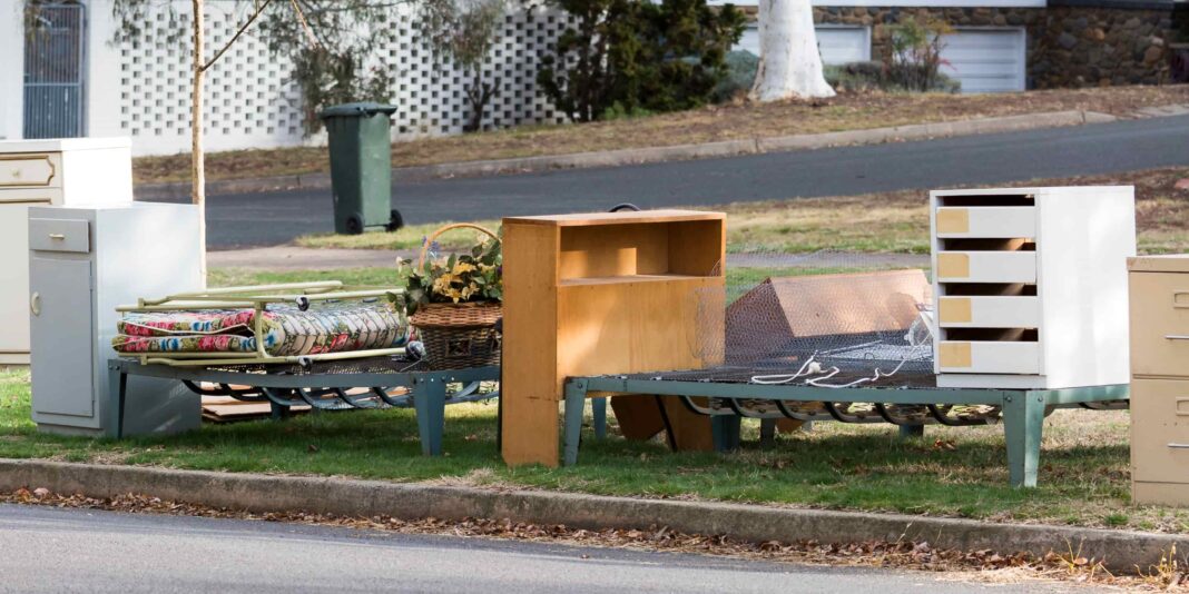 Bulky waste on an ACT street including a bookshelf, bed base, chest of drawers and a basket.
