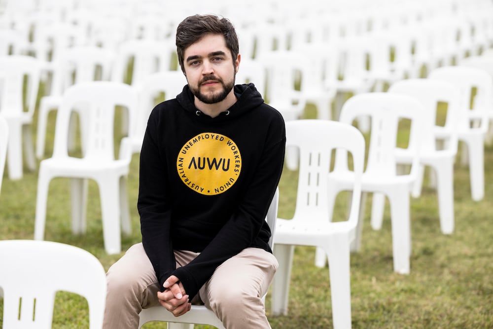 ACT unemployed worker David Cribb wears an AUWU hoodie and sits amongst thousands of empty plastic chairs