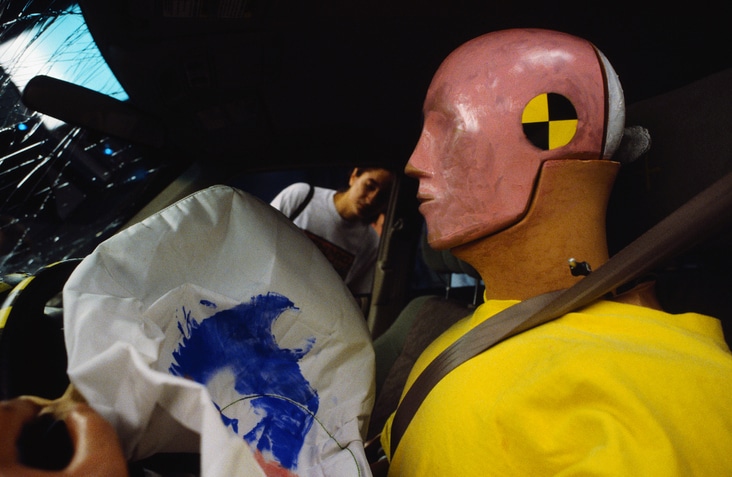 A crash test dummy in a car with airbags