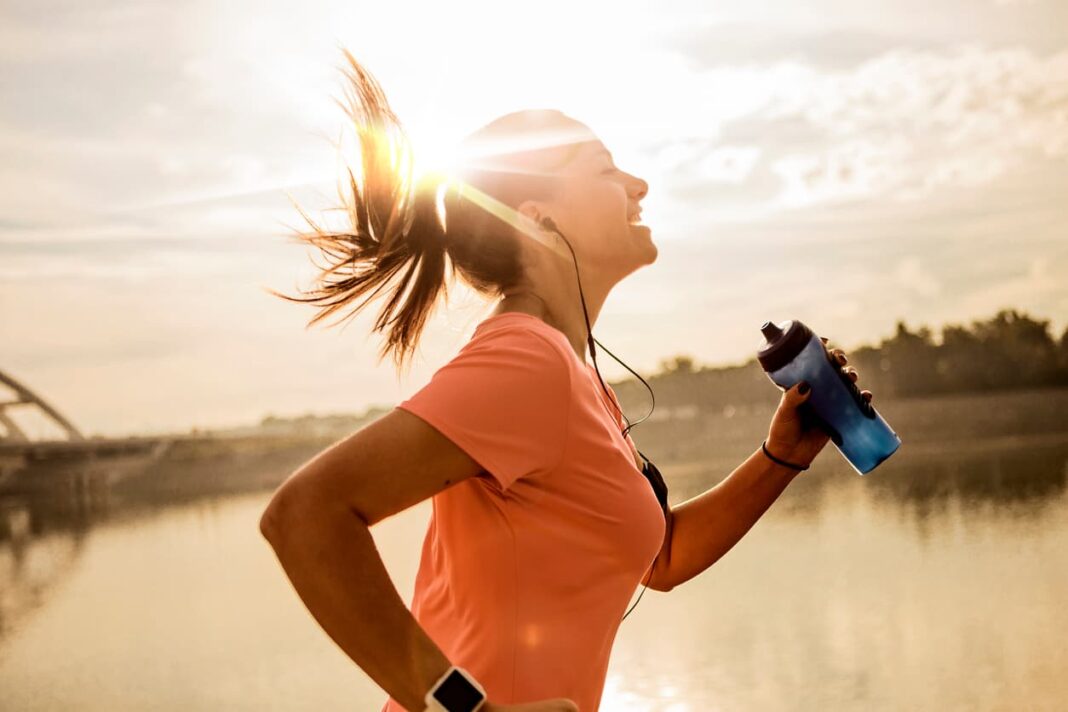 woman jogging with sun setting in background