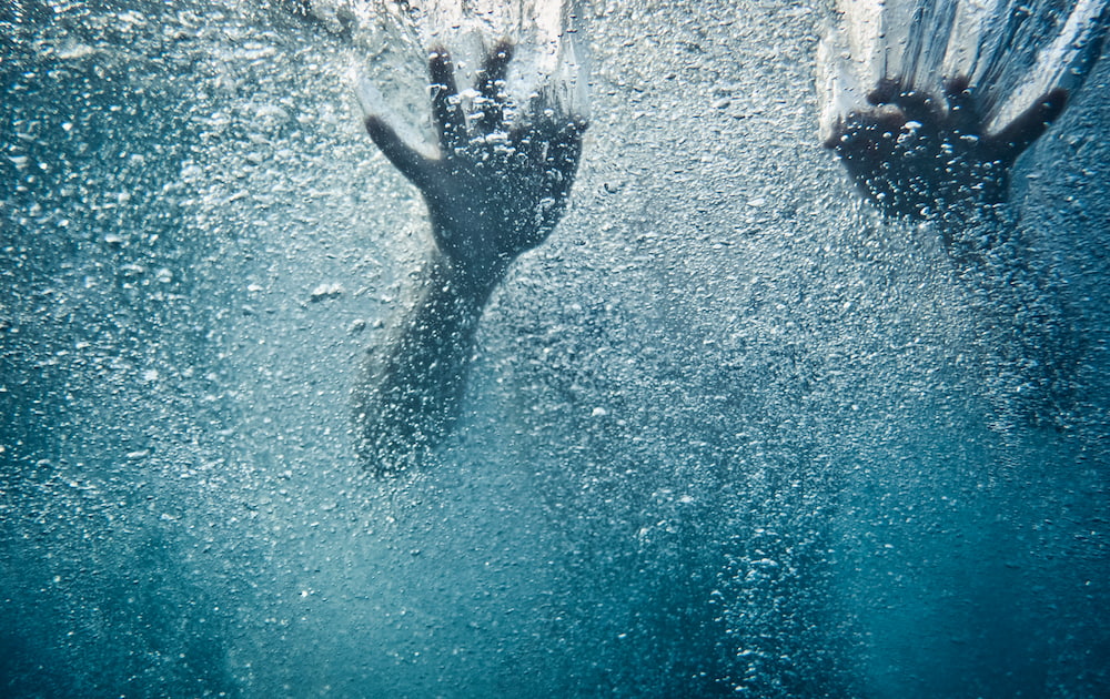 Disaster tourism can lead to drowning, as symbolised by this photo of hands under turbulent water