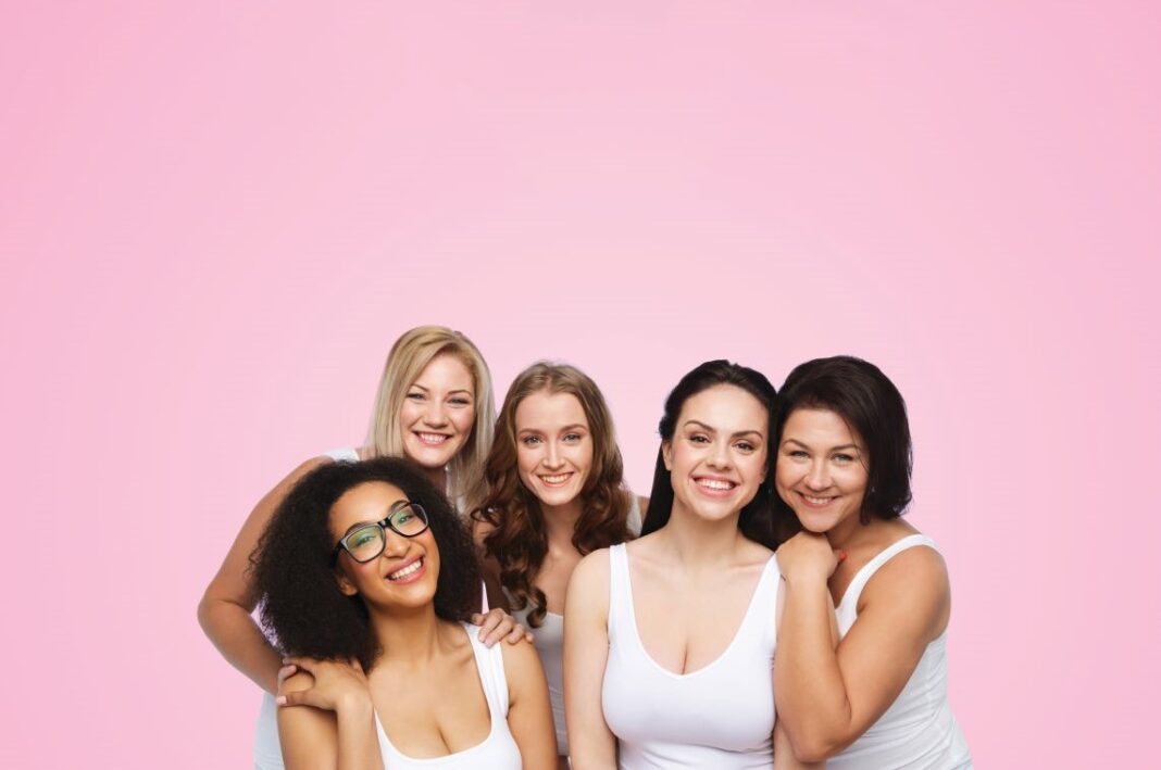 group of women in front of pink background
