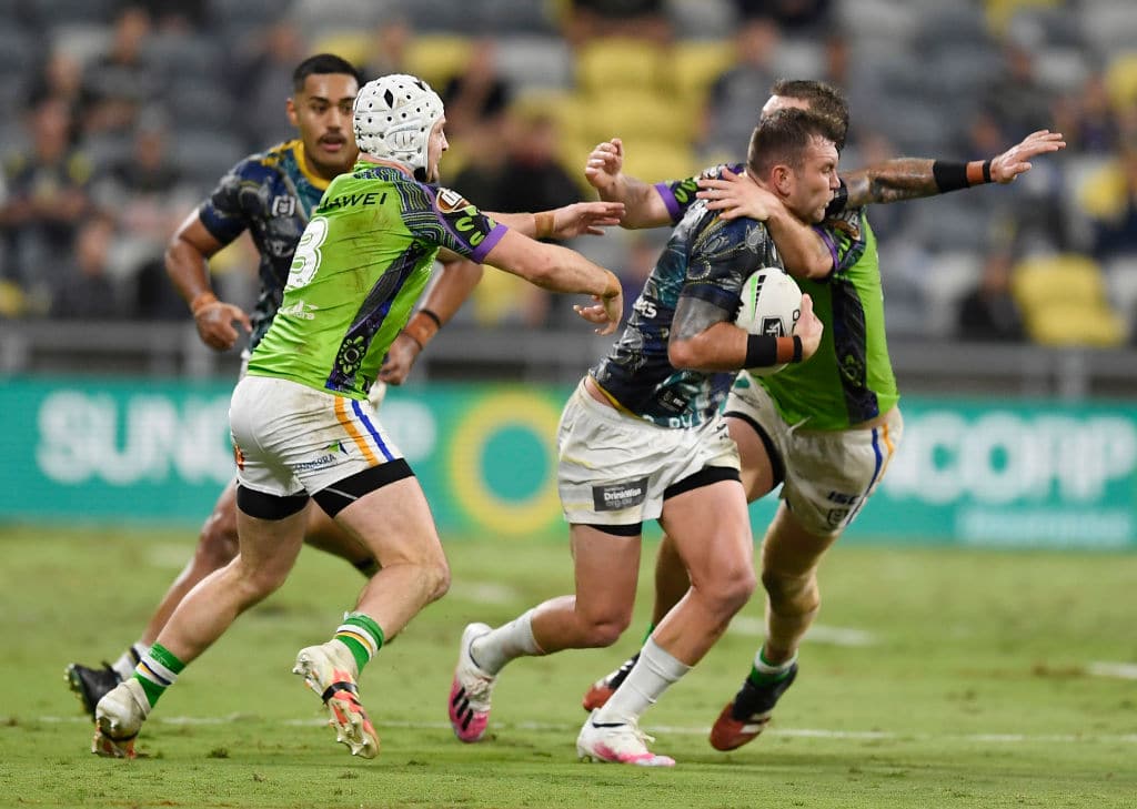 TOWNSVILLE, AUSTRALIA - AUGUST 01: Kyle Feldt of the Cowboys is wrapped up by the Raiders defence during the round 12 NRL match between the North Queensland Cowboys and the Canberra Raiders at QCB Stadium on August 01, 2020 in Townsville, Australia. (Photo by Ian Hitchcock/Getty Images)