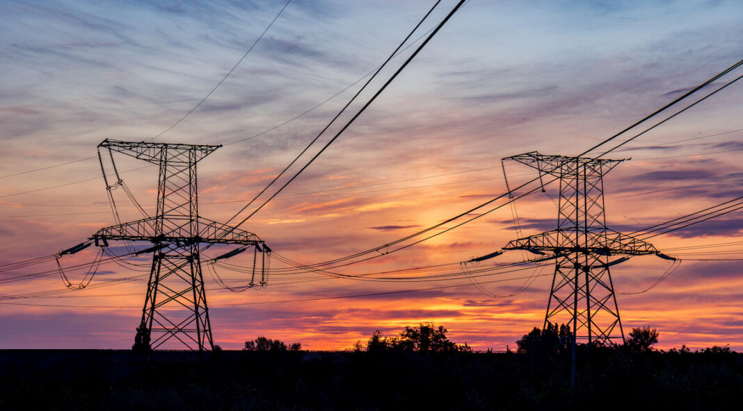 Powerlines are backlit by a colourful sunlight in this photo that accompanies a story about ACT energy retailers