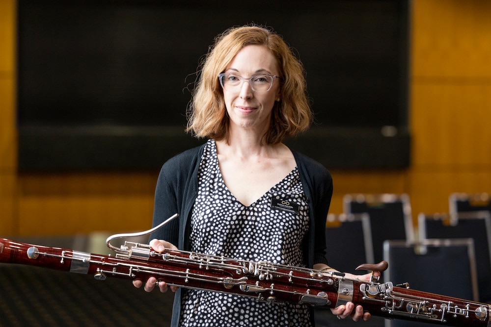 slender middle aged woman with auburn hair holding an oboe