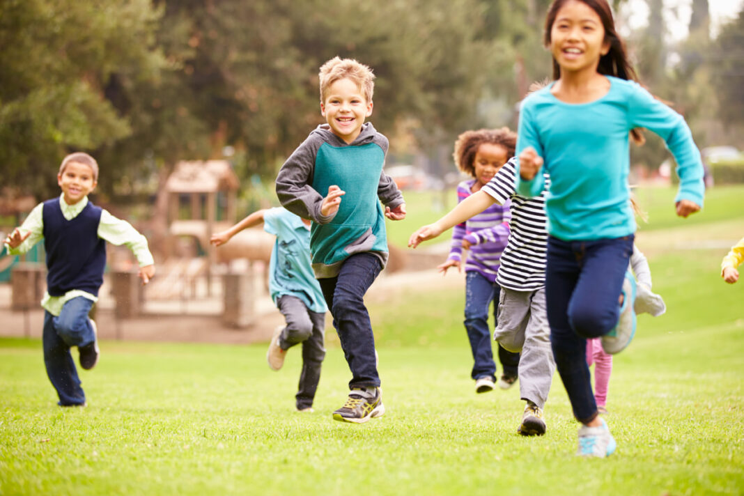 several children aged around 10 running in a park